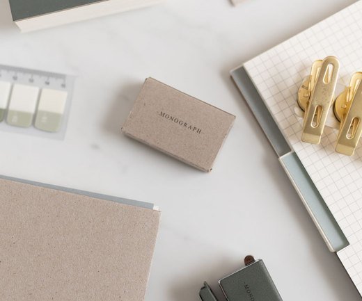 Grid notebook with a pen and gold clips